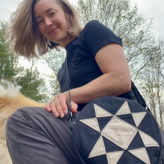 Person holding a navy blue bag with a white star pattern outdoors